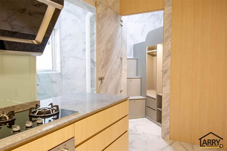 After: kitchen with light wood-tone cabinets, a stone-look worktop, gas hob and marble-look wall tiles - HDB flat renovation with full-height carpentry and a wood-tone kitchen (C12) | Larry Contractors, HDB Licensed Renovation Contractor, Singapore