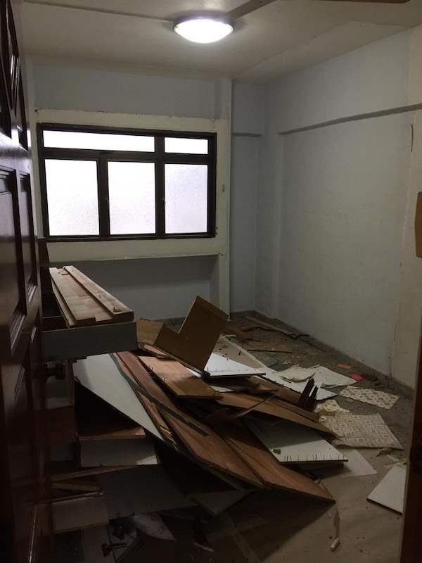 During demolition: old timber panels and debris piled on the floor of a room - HDB resale flat renovation with polished terrazzo floors, new kitchen and bathrooms (C04) | Larry Contractors, HDB Licensed Renovation Contractor, Singapore