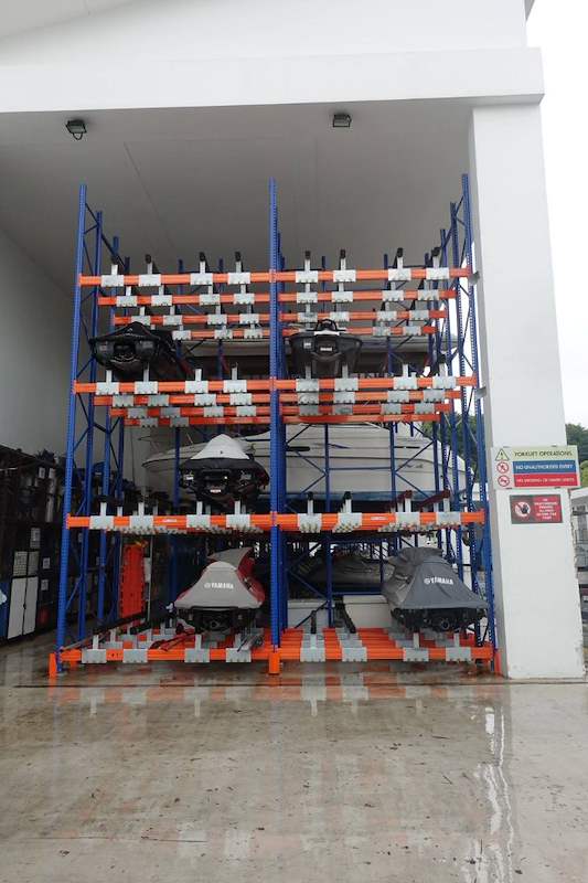 Tall boat and jet ski rack in a shed bay, jet skis on timber bunks at each level and a wet concrete floor - Heavy-duty storage racking for boats and jet skis (Sentosa) | Larry Contractors, HDB Licensed Renovation Contractor, Singapore
