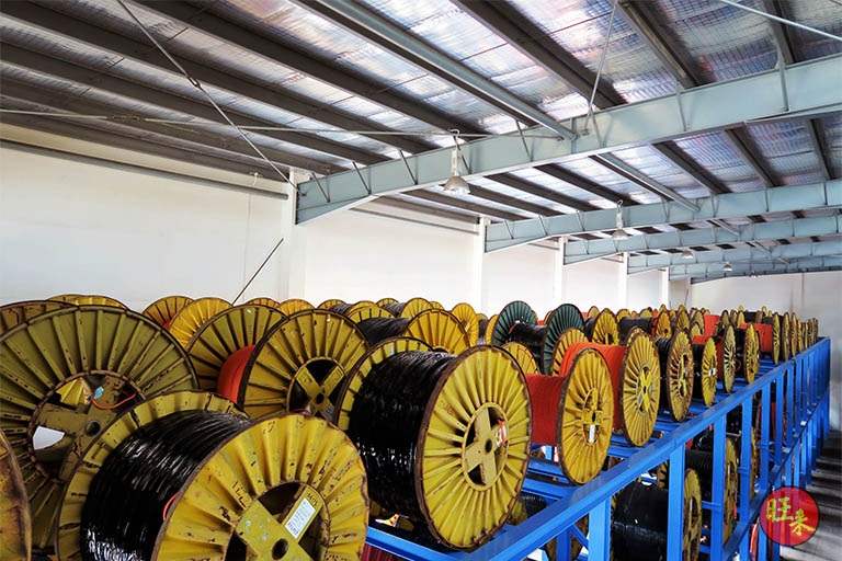 Rows of cable drums stored at ground level under the shed roof before the upper tier is loaded - Heavy-duty cable drum racking in a cable yard (TSE) | Larry Contractors, HDB Licensed Renovation Contractor, Singapore