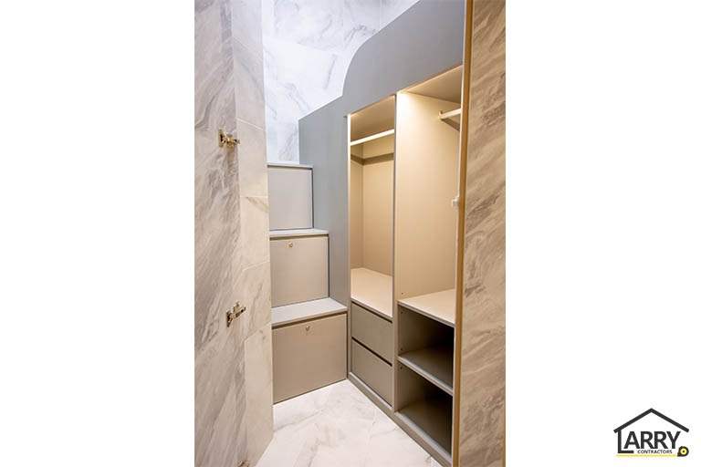 Walk-in wardrobe with open shelving and drawers behind marble-look wall panels - HDB flat renovation with full-height carpentry and a wood-tone kitchen (C12) | Larry Contractors, HDB Licensed Renovation Contractor, Singapore