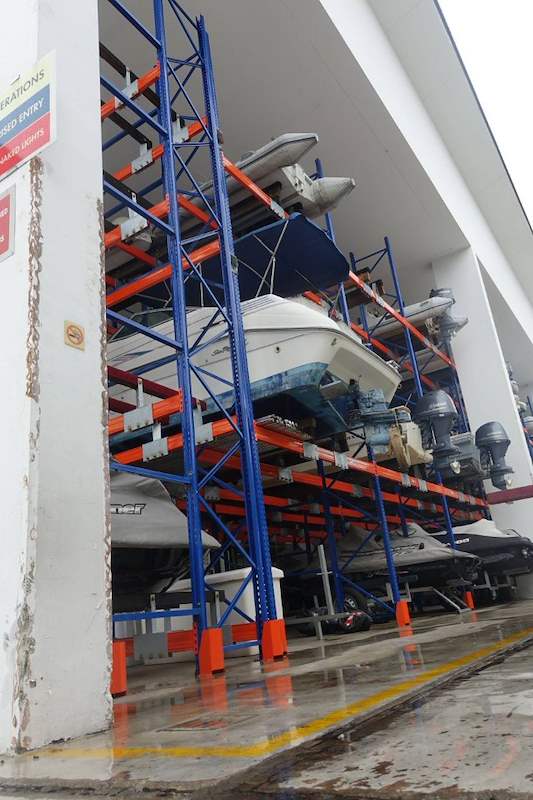 Boats stored on three tiers of racking beside a shed column, yellow floor markings on the wet floor - Heavy-duty storage racking for boats and jet skis (Sentosa) | Larry Contractors, HDB Licensed Renovation Contractor, Singapore