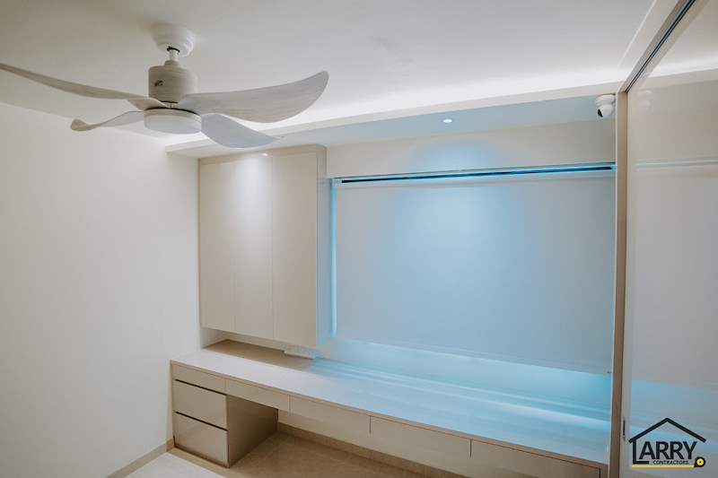 Bedroom with a ceiling fan, built-in desk and drawers under the window and cove lighting - HDB flat renovation in cream and mirror-trim laminate with a galley kitchen (C10) | Larry Contractors, HDB Licensed Renovation Contractor, Singapore