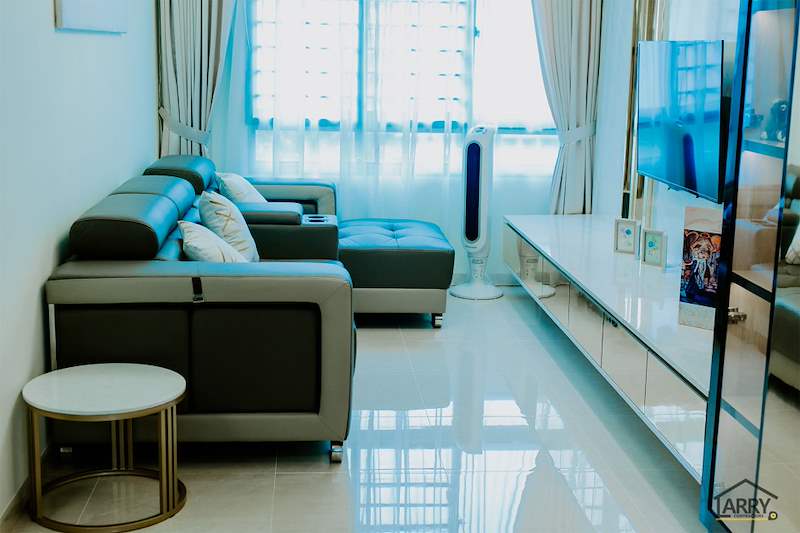 Living room with a leather sofa, round side table, floating TV console and a mirror-strip feature wall - HDB flat renovation in cream and mirror-trim laminate with a galley kitchen (C10) | Larry Contractors, HDB Licensed Renovation Contractor, Singapore