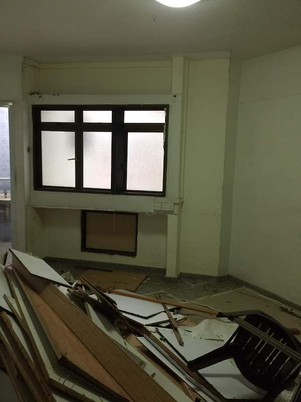 During demolition: a room with old timber and debris on the floor and grilled windows - HDB resale flat renovation with polished terrazzo floors, new kitchen and bathrooms (C04) | Larry Contractors, HDB Licensed Renovation Contractor, Singapore