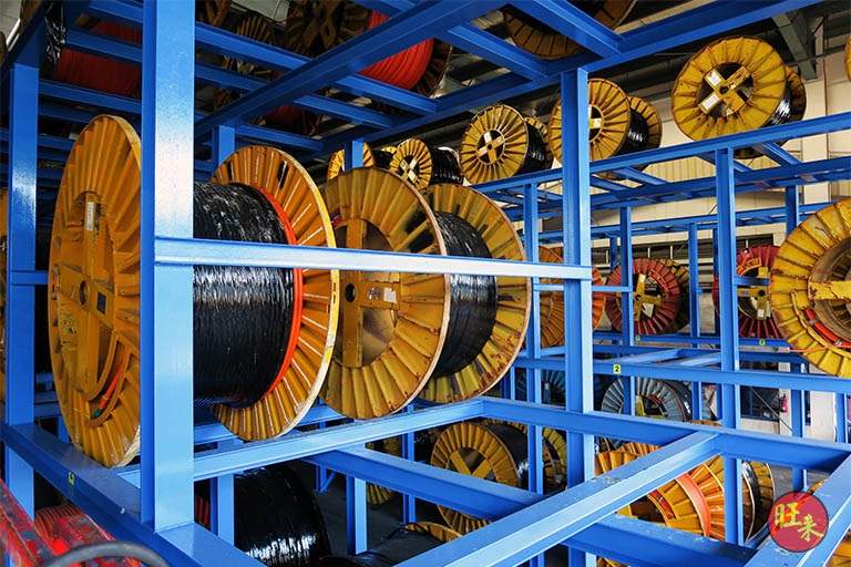 Cable drums sitting on the steel beams of the two-tier rack, close view of the blue framing - Heavy-duty cable drum racking in a cable yard (TSE) | Larry Contractors, HDB Licensed Renovation Contractor, Singapore