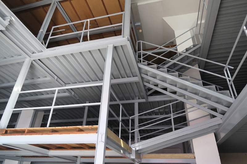 Looking up through the steel mezzanine framing, railings and stair flights - Two-level steel mezzanine with staircases in an industrial unit (HF0107) | Larry Contractors, HDB Licensed Renovation Contractor, Singapore
