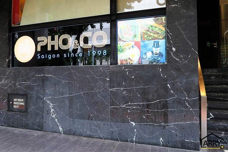 Restaurant shopfront in dark veined marble with a backlit sign and a lightbox food display - Restaurant fit-out with an open kitchen counter and marble frontage (C48) | Larry Contractors, HDB Licensed Renovation Contractor, Singapore