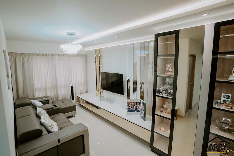 Living room looking towards the window, floating TV console and glass display cabinet on the right - HDB flat renovation in cream and mirror-trim laminate with a galley kitchen (C10) | Larry Contractors, HDB Licensed Renovation Contractor, Singapore