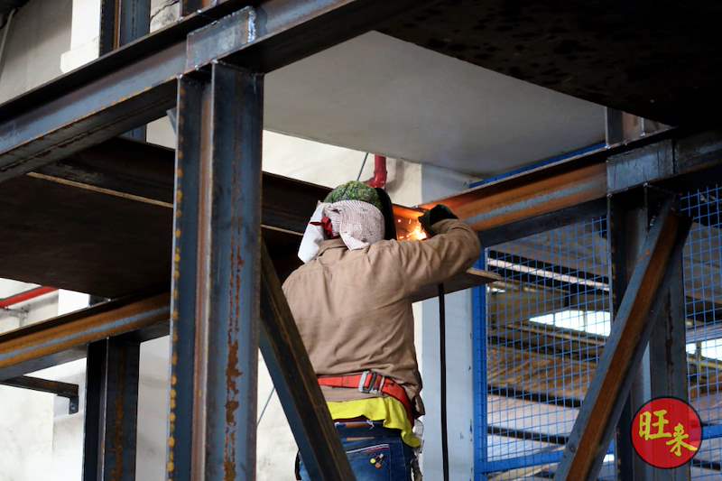 During works: a welder joining a beam to a column of the steel frame inside the shed - Heavy-duty cable drum racking in a cable yard (TSE) | Larry Contractors, HDB Licensed Renovation Contractor, Singapore