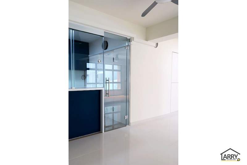 Glass sliding door into the kitchen, with blue cabinet fronts visible through it - HDB flat renovation with a platform bay window seat and blue kitchen (C20) | Larry Contractors, HDB Licensed Renovation Contractor, Singapore