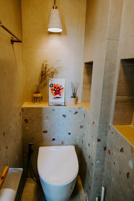 Bathroom with a terrazzo-look tiled shelf, wall-hung toilet and a pendant light - Full HDB maisonette renovation with a curved timber-slat island and lit staircase (140BB) | Larry Contractors, HDB Licensed Renovation Contractor, Singapore