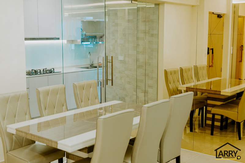Dining table with cream upholstered chairs beside the glass-walled kitchen - HDB flat renovation in cream and mirror-trim laminate with a galley kitchen (C10) | Larry Contractors, HDB Licensed Renovation Contractor, Singapore