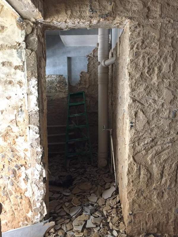 During works: a hacked doorway with exposed brick and a ladder beyond - HDB resale flat renovation with polished terrazzo floors, new kitchen and bathrooms (C04) | Larry Contractors, HDB Licensed Renovation Contractor, Singapore